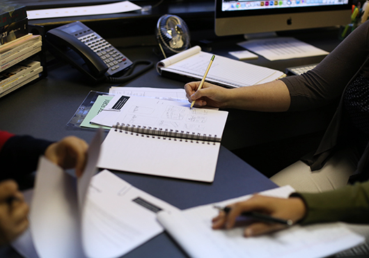 person working at desk with notebooks