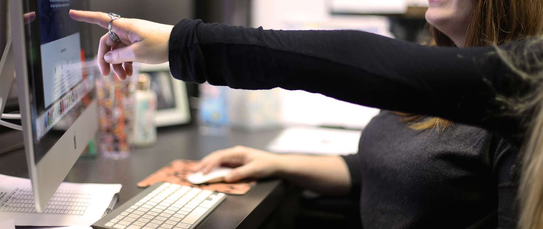 Woman pointing at computer screen